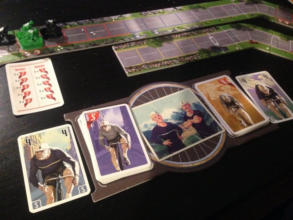 Foto del juego Flamme Rouge en la que vemos cuatro miniaturas juntas afrontando una subida y el tablero personal en primer plano.